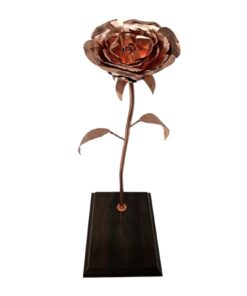 Vista frontal de rosa de cobre artesanal sobre base de madera